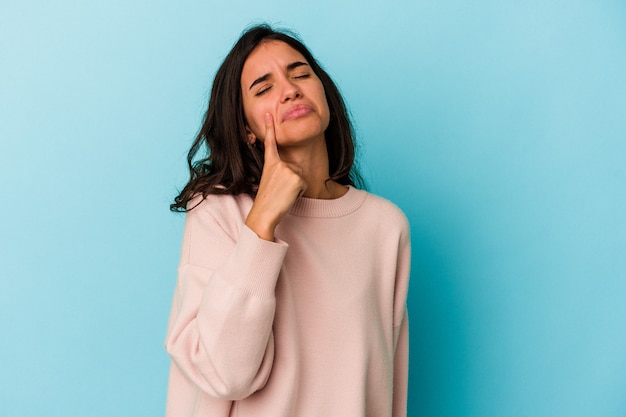 Young caucasian woman isolated on blue background crying, unhappy with something, agony and confusion concept.