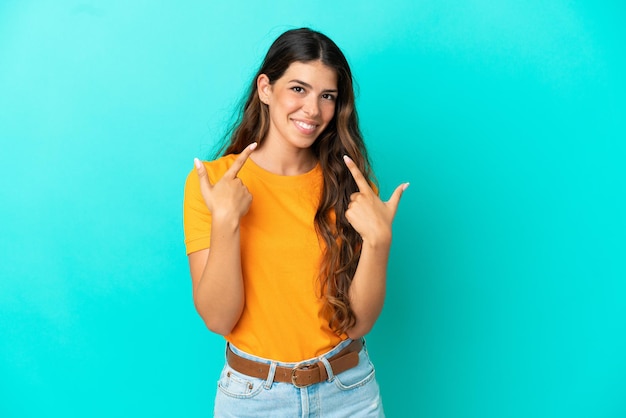 Young caucasian woman isolated on blue background giving a thumbs up gesture