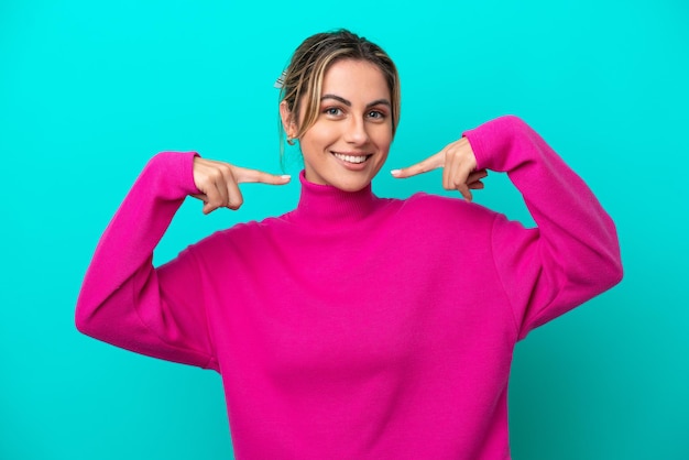 Young caucasian woman isolated on blue background giving a thumbs up gesture