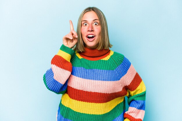 Young caucasian woman isolated on blue background having an idea inspiration concept