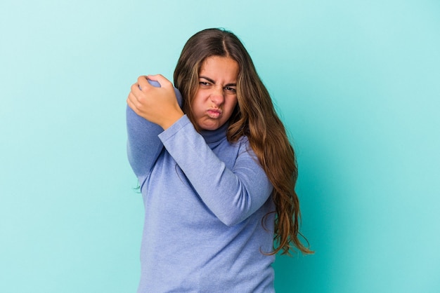 Young caucasian woman isolated on blue background  having a neck pain due to stress, massaging and touching it with hand.