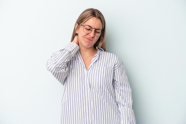 Young caucasian woman isolated on blue background having a neck pain due to stress, massaging and touching it with hand.