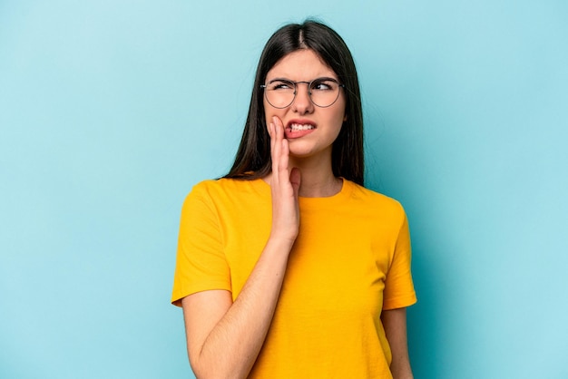 Young caucasian woman isolated on blue background having a strong teeth pain molar ache