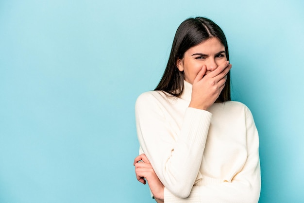 Young caucasian woman isolated on blue background laughing happy carefree natural emotion