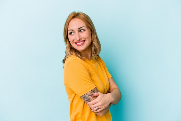 Young caucasian woman isolated on blue background laughing and having fun.