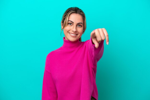 Photo young caucasian woman isolated on blue background pointing front with happy expression