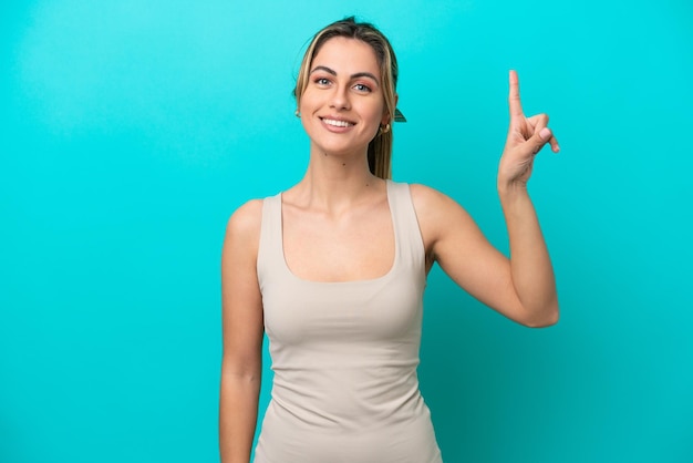 Young caucasian woman isolated on blue background pointing up a great idea