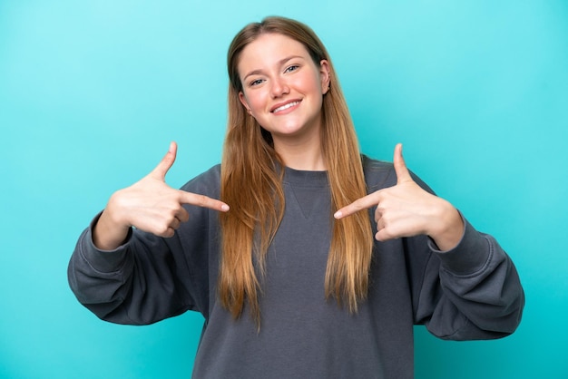 Young caucasian woman isolated on blue background proud and selfsatisfied