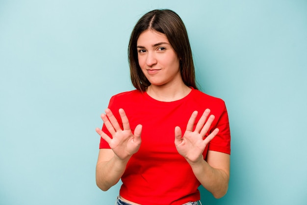 Young caucasian woman isolated on blue background rejecting someone showing a gesture of disgust