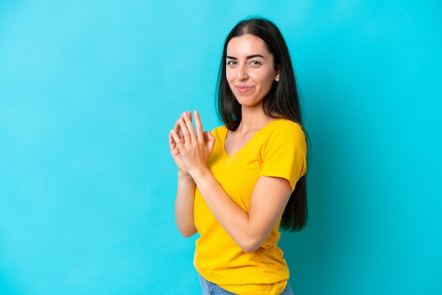 Young caucasian woman isolated on blue background scheming something