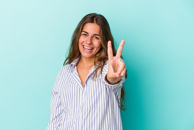 Young caucasian woman isolated on blue background  showing number two with fingers.