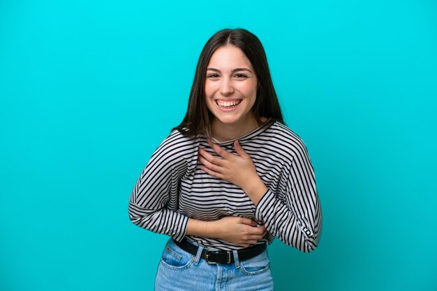 Young caucasian woman isolated on blue background smiling a lot