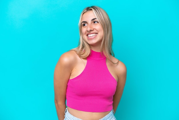 Young caucasian woman isolated on blue background thinking an idea while looking up