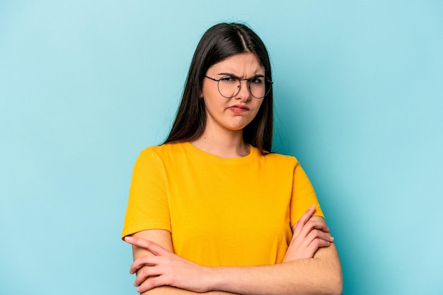 Young caucasian woman isolated on blue background unhappy looking in camera with sarcastic expression