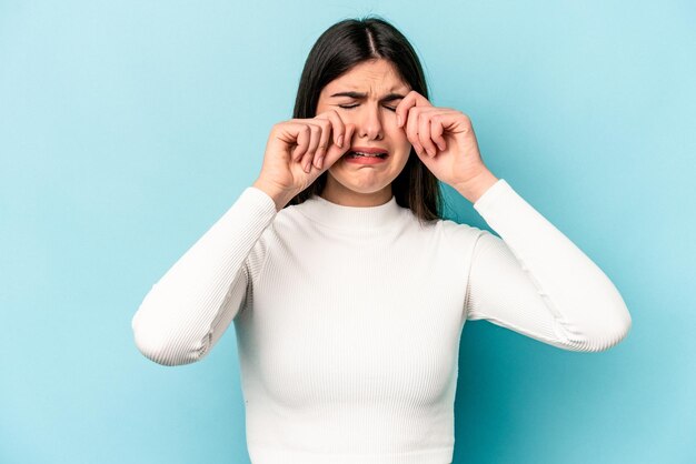 Young caucasian woman isolated on blue background whining and crying disconsolately