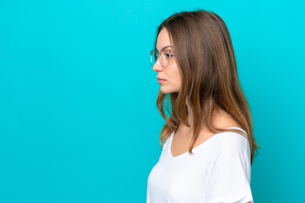 Young caucasian woman isolated on blue background With glasses