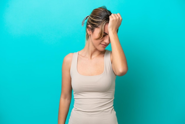 Photo young caucasian woman isolated on blue background with headache
