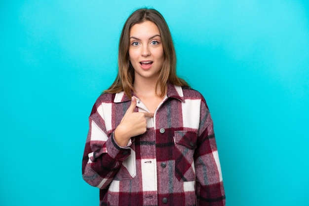 Young caucasian woman isolated on blue background with surprise facial expression