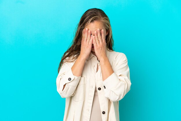 Young caucasian woman isolated on blue background with tired and sick expression