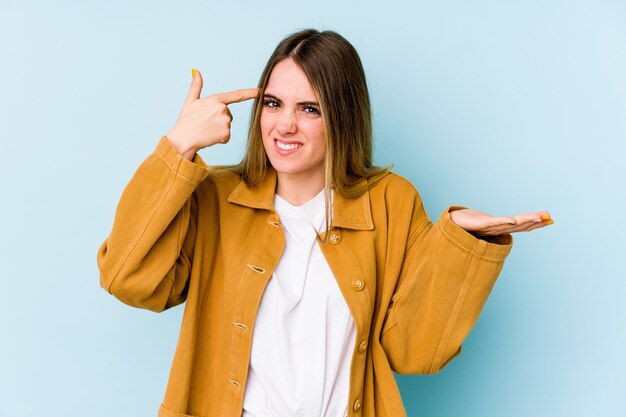 Young caucasian woman isolated on blue showing a disappointmont gesture with forefinger.