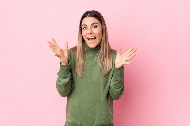 Young caucasian woman isolated celebrating a victory or success, he is surprised and shocked.