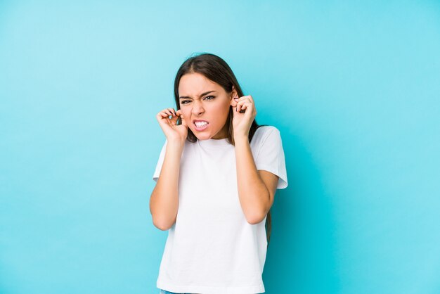 Young caucasian woman  isolated covering ears with hands.