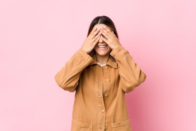 Young caucasian woman isolated covers eyes with hands, smiles broadly waiting for a surprise.