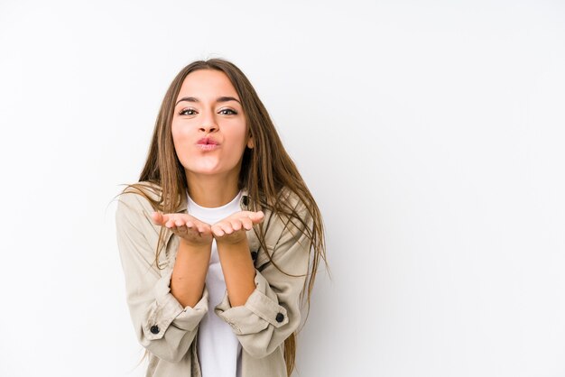 La giovane donna caucasica ha isolato le labbra pieganti e le palme della tenuta per inviare il bacio dell'aria.