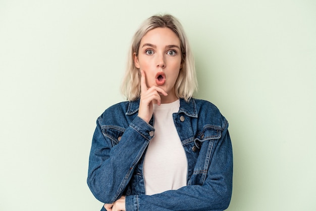 Young caucasian woman isolated on green background having some great idea, concept of creativity.