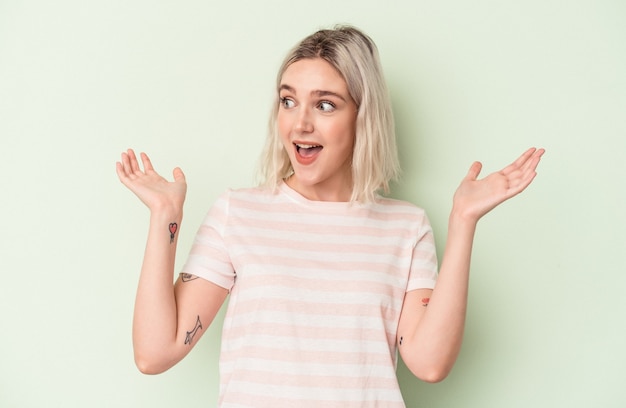 Young caucasian woman isolated on green background joyful laughing a lot. Happiness concept.