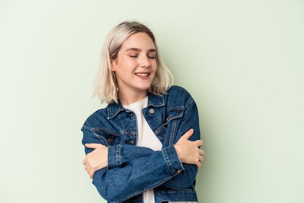 Photo young caucasian woman isolated on green background laughing and having fun.