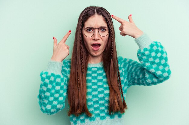 Young caucasian woman isolated on green background showing a disappointment gesture with forefinger