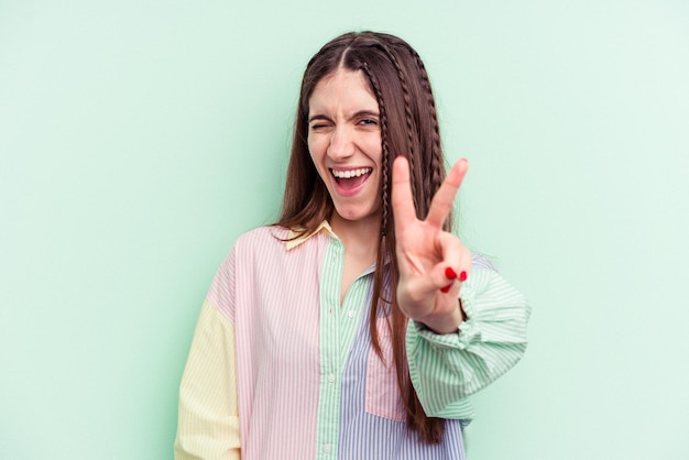 Young caucasian woman isolated on green background showing number two with fingers.