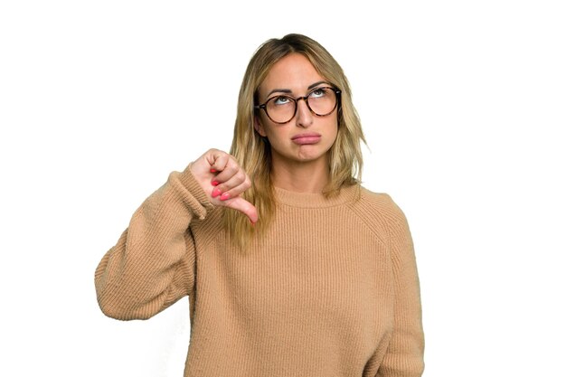 Photo young caucasian woman isolated on green chroma background showing a dislike gesture thumbs down