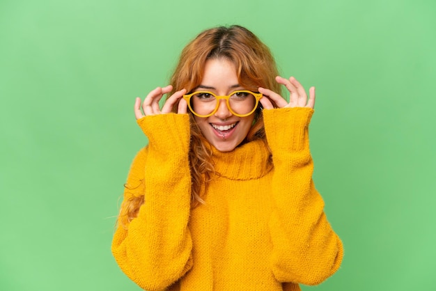 Young caucasian woman isolated on green screen chroma key background With glasses with happy expression