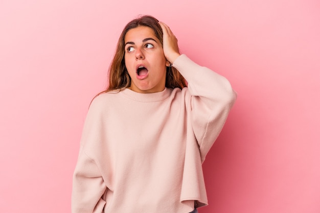 Young caucasian woman isolated on pink background  being shocked, she has remembered important meeting.