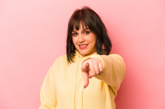 Young caucasian woman isolated on pink background cheerful smiles pointing to front