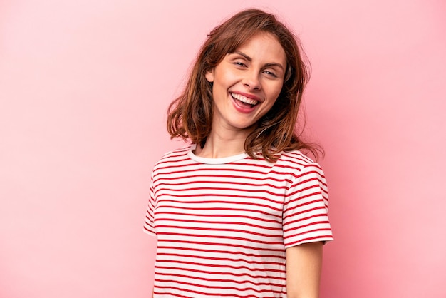 Young caucasian woman isolated on pink background confident keeping hands on hips