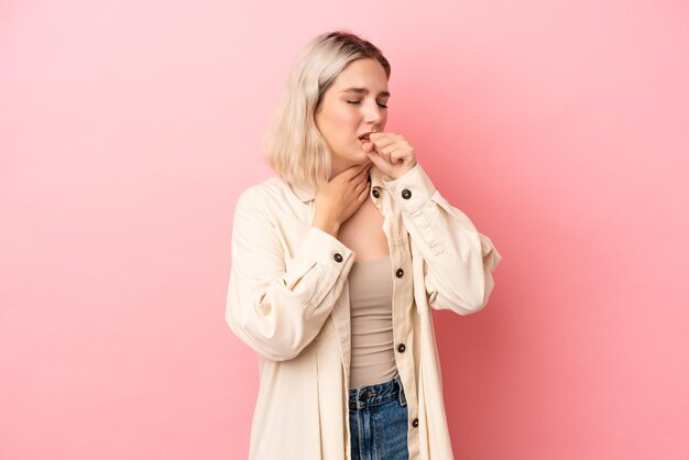 Young caucasian woman isolated on pink background coughing a lot