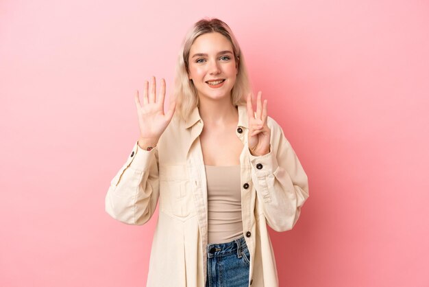 Young caucasian woman isolated on pink background counting eight with fingers