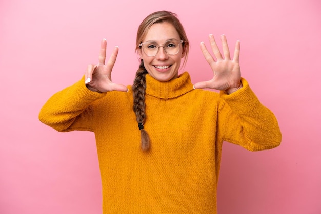 Young caucasian woman isolated on pink background counting eight with fingers
