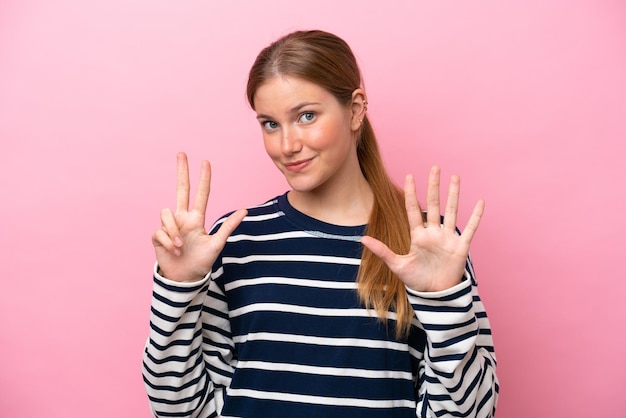 Young caucasian woman isolated on pink background counting eight with fingers