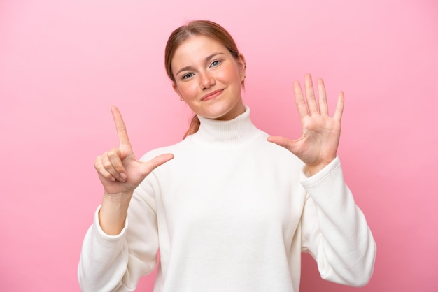 Young caucasian woman isolated on pink background counting seven with fingers