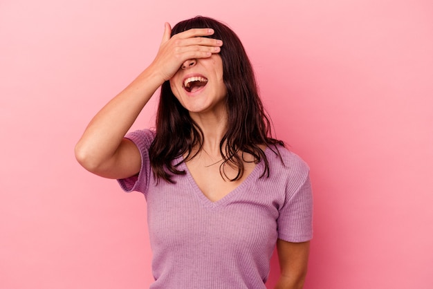 Young caucasian woman isolated on pink background covers eyes with hands, smiles broadly waiting for a surprise.