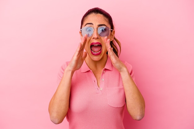 Young caucasian woman isolated on pink background doubting and shrugging shoulders in questioning gesture.