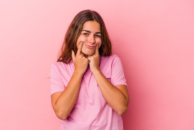 Young caucasian woman isolated on pink background  doubting between two options.