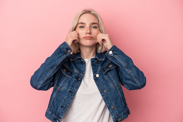 Young caucasian woman isolated on pink background doubting between two options.