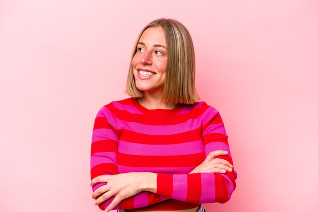 Young caucasian woman isolated on pink background dreaming of achieving goals and purposes