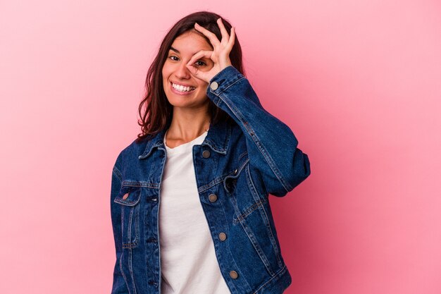 Young caucasian woman isolated on pink background excited keeping ok gesture on eye.