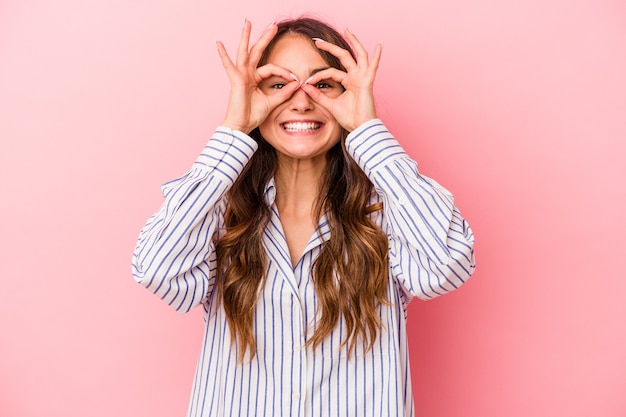 Young caucasian woman isolated on pink background excited keeping ok gesture on eye.